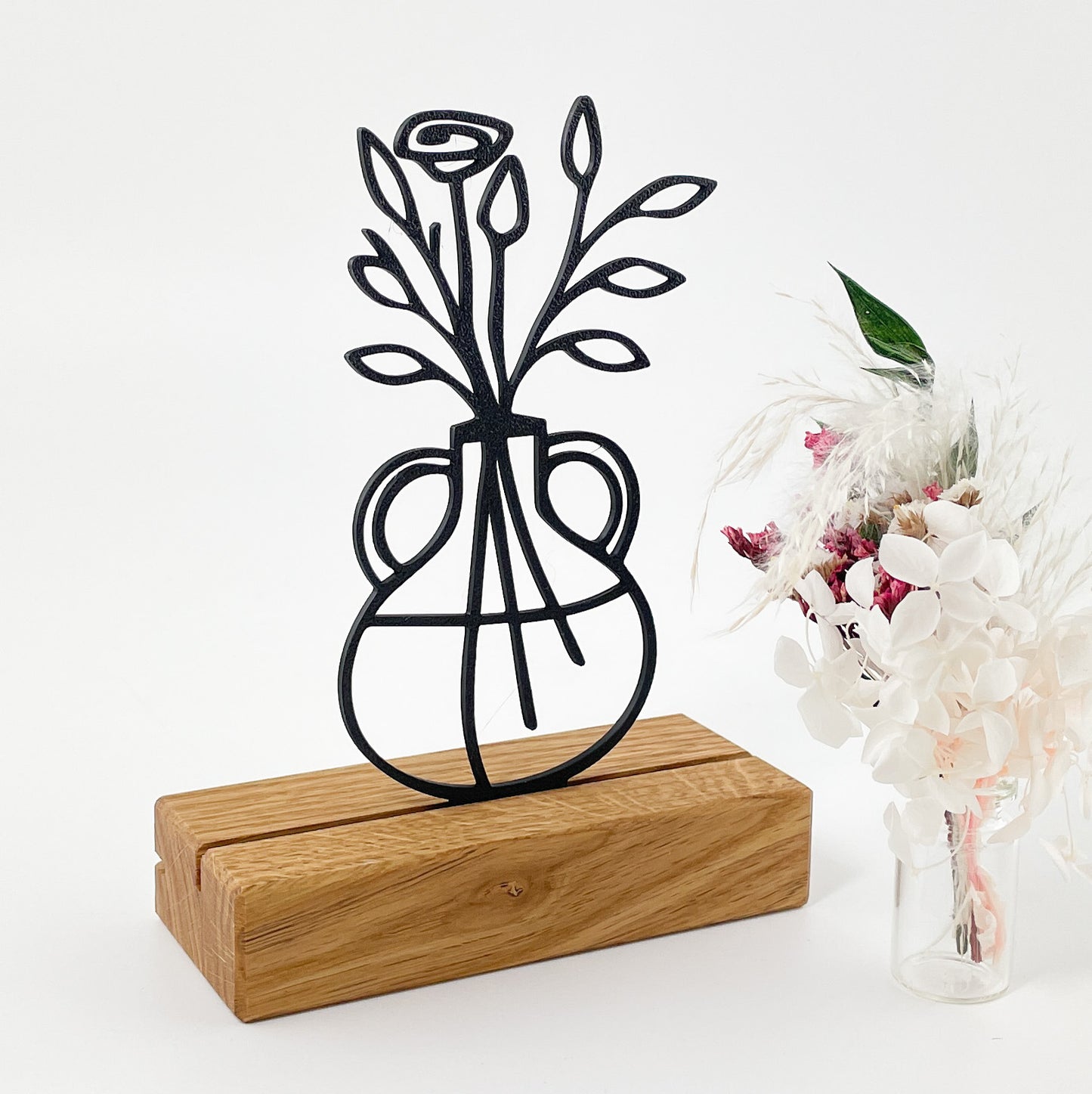 Eine minimalistisch gezeichnete Blumenvase aus schwarzem Kunststoff