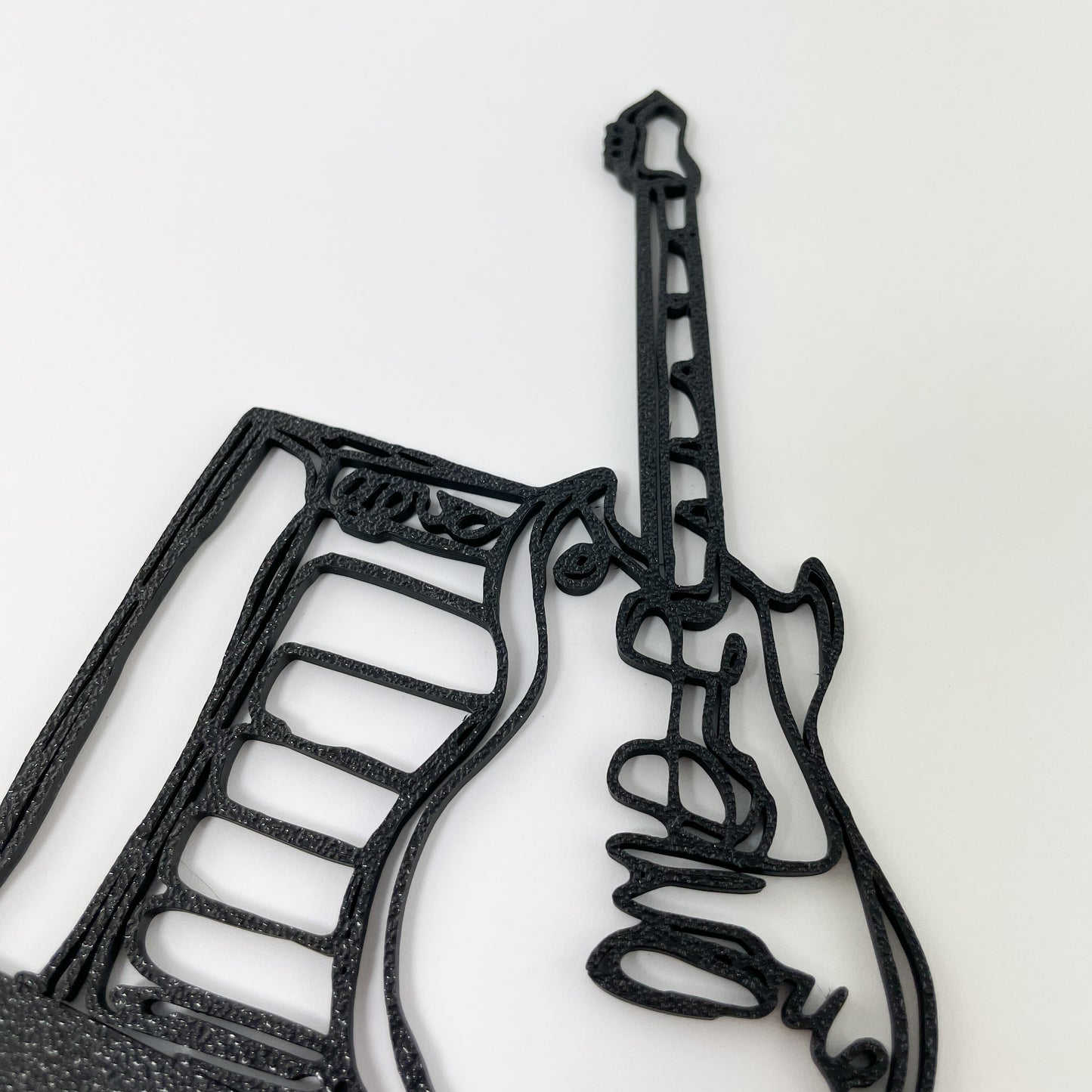 Detailaufnahme der 3D-gedruckten E-Gitarre mit Verstärker im Stil einer filigranen Linienzeichnung. Die Oberflächenstruktur des Kunststoffs ist gut zu sehen und der Hintergrund weiß.