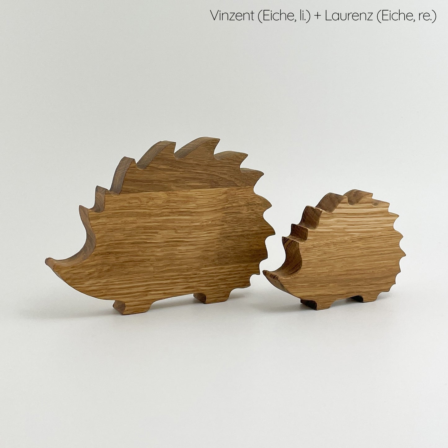 Rückseite von Holz Igel set- Vinzent und Laurenz, auf weißem Hintergrund. Vinzent ist das größere Modell auf der linken Seite, während Laurenz rechts kleiner ist. Beide sind aus Eichenholz gefertigt und zeigen die natürliche Maserung des Holzes.
