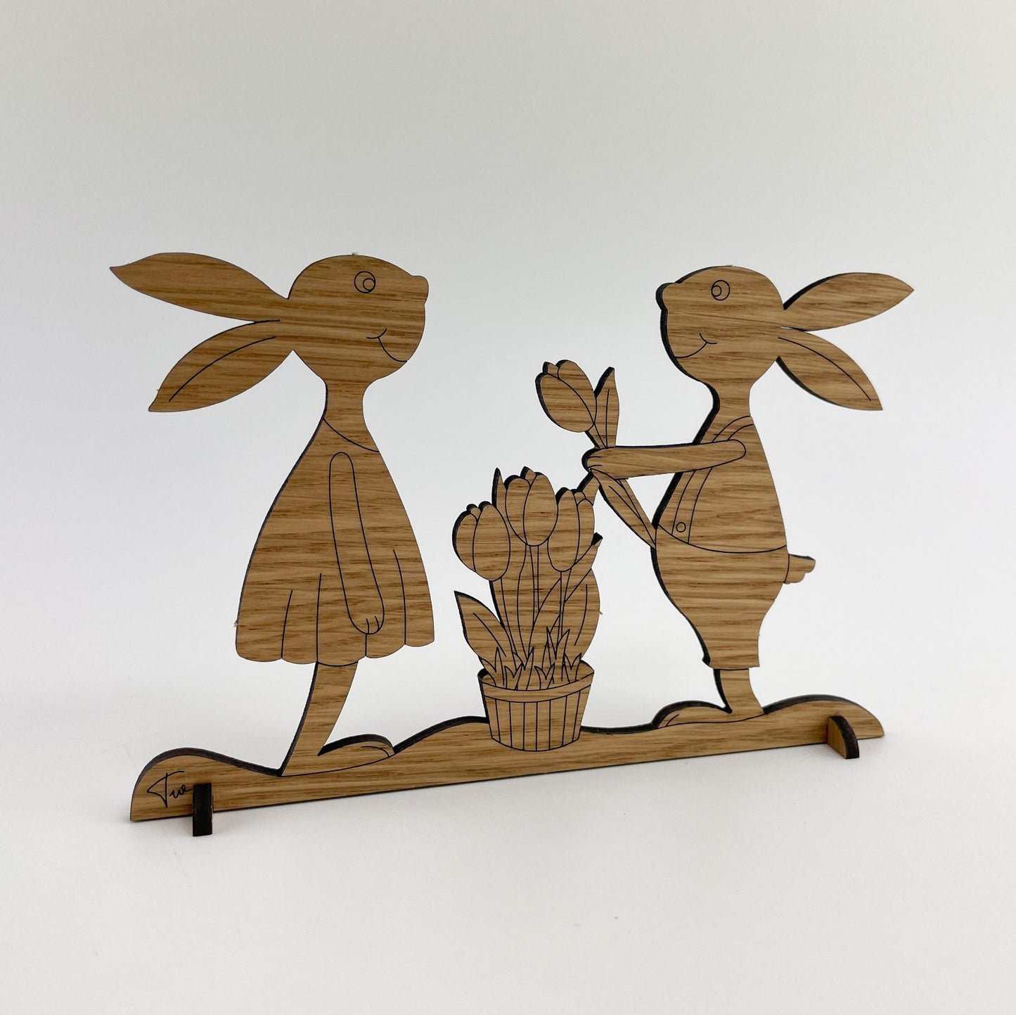 Rückseite von Holz-Osterkarte Papaja & Pepito mit zwei ausgeschnittenen Hasenfiguren, die aufrecht auf einer Basis stehen. Beide Figuren sind detailliert mit Linien versehen, die die Holzmaserung darstellen. Die Szene vermittelt eine fröhliche Osterstimmung.
