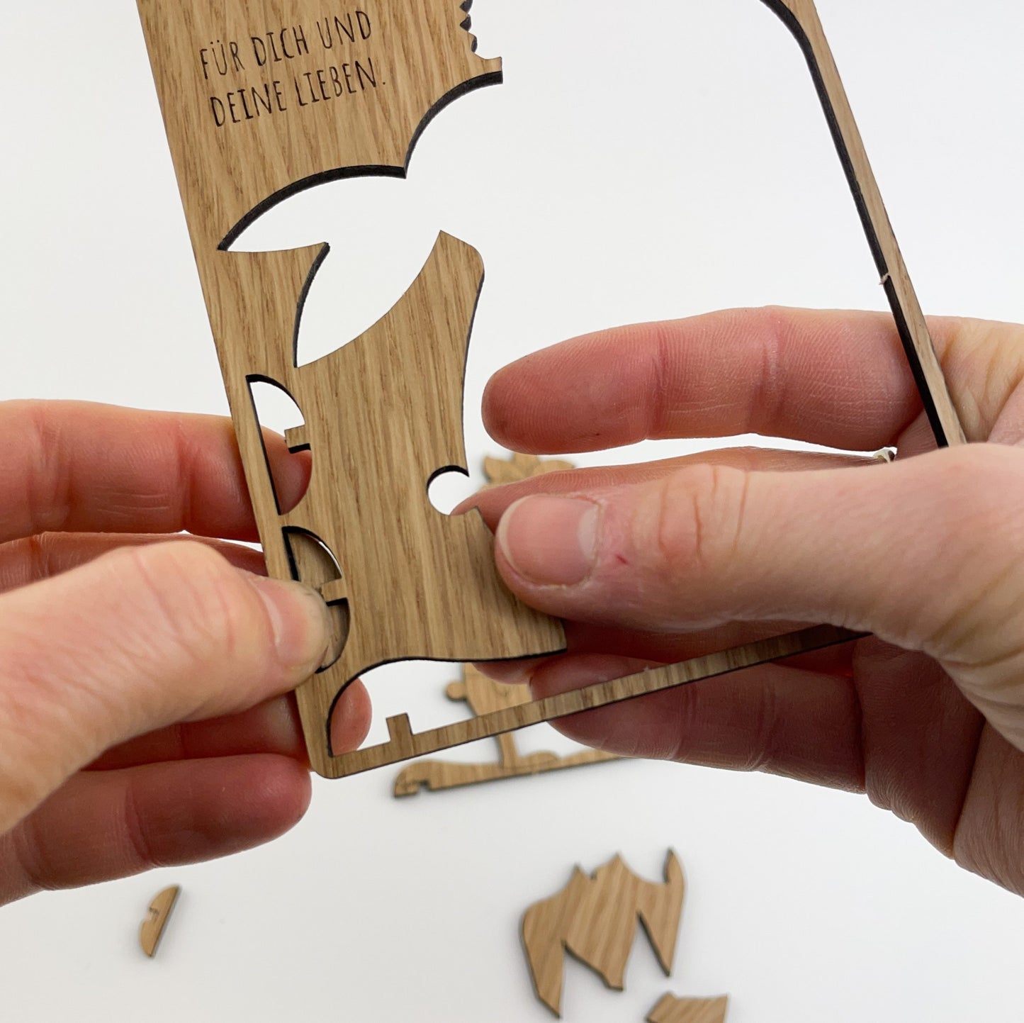 Die detaillierte Holz-Osterkarte Pino ist eine wunderschön gestaltete Osterkarte aus Holz. Sie zeigt ein detailliert ausgeschnittenes Design eines Hasen, mit unterschiedlichen Formen für Ohren, Körper und Schwanz. Die Karte enthält auch kleine Einzelteile, die in die größeren Ausschnitte passen, was sie zu einer Art Puzzle macht. Oben auf der Karte ist ein deutscher Text eingraviert, der übersetzt "FÜR DICH UND DEINE LIEBEN" bedeutet und der Karte eine persönliche und herzliche Note verleiht.