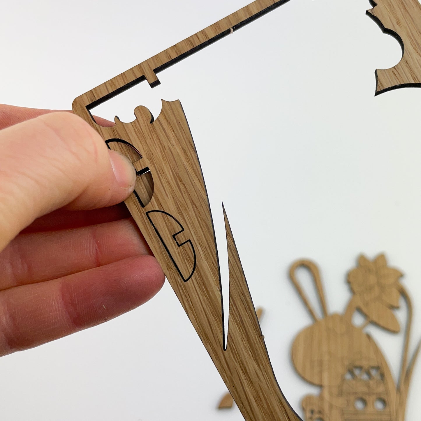 Detailansicht von Holz-Osterkarte Pascal. Sie ist nicht nur eine außergewöhnliche Grußkarte, sondern verwandelt sich nach einer kleinen Fingerübung in eine wiederverwendbare Osterdekoration. Die Karte besteht aus hochwertigem Furnierholz mit einem Kern aus hochdichter Faserplatte (HDF) und einer Deckschicht aus Eichenholz.