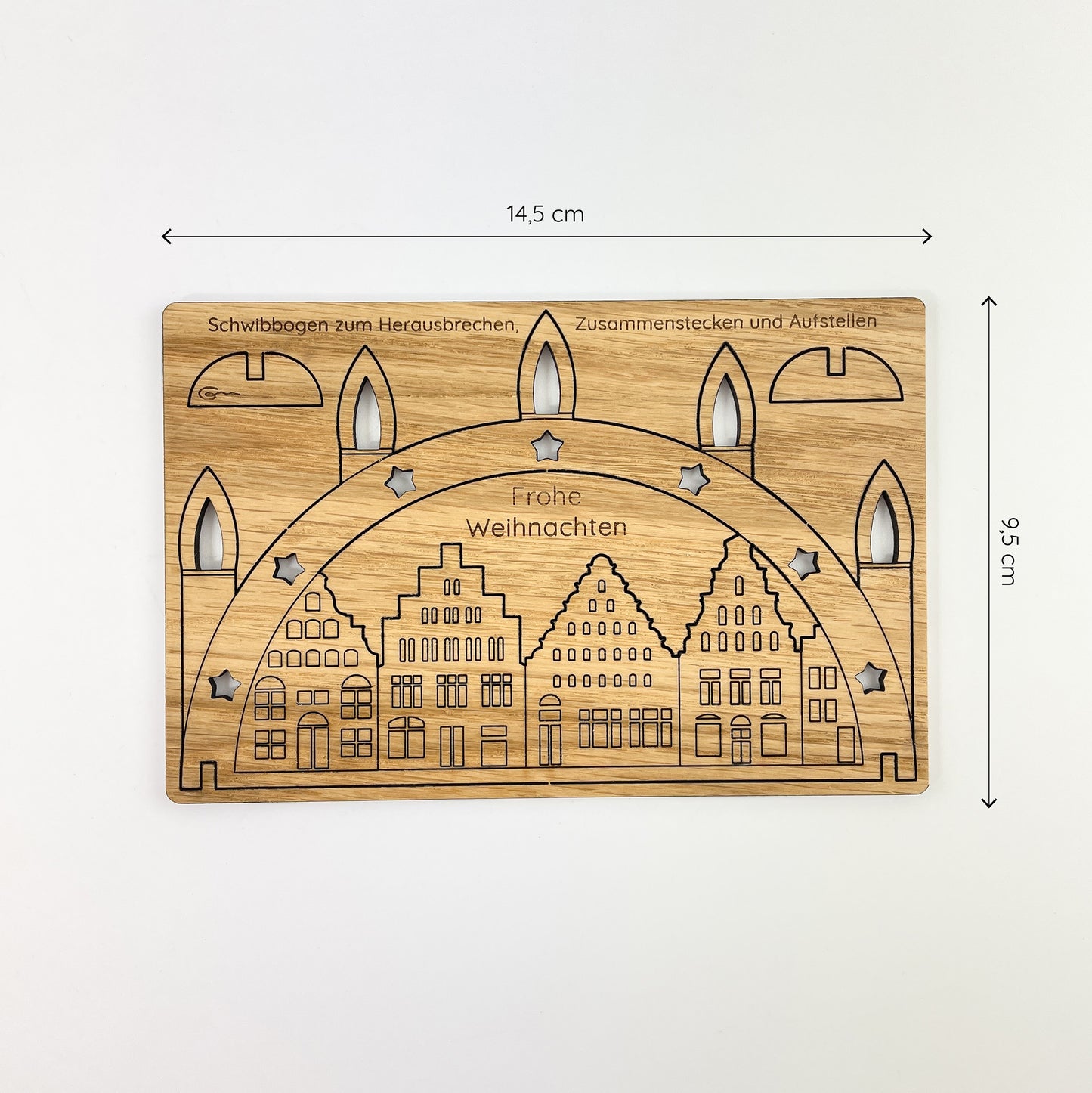 Ansicht der Holz-Weihnachtskarte von oben vor weißem Hintergrund mit Maßketten, welche die Größe der Karte anzeigt. Sie ist 14.5cm breit und 9.5cm hoch.