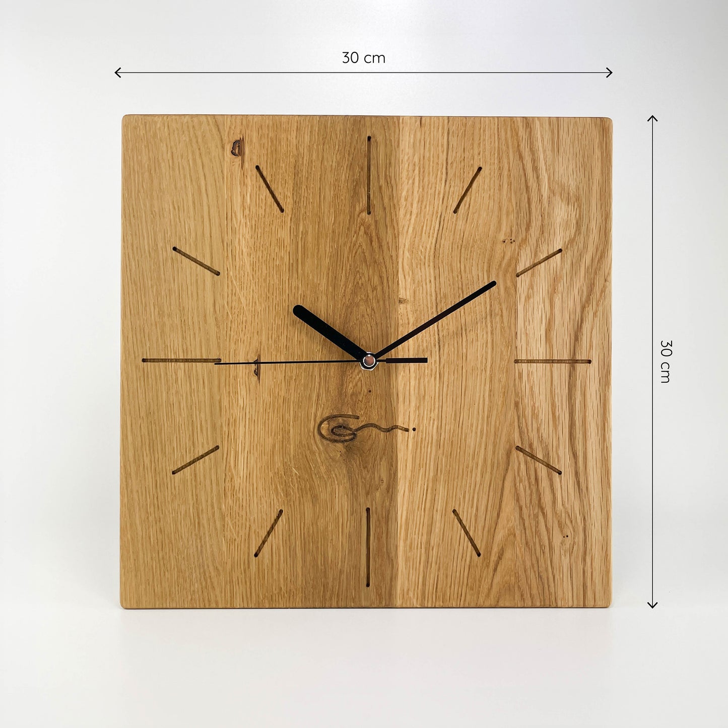 Frontalansicht einer eckigen Holz-Wanduhr mit schwarzen Zeigern, bei der die Zahlen die die Stunden durch eingravierte Striche markiert sind und Maße von 30x30 cm sind an der rechten und oberen Seite abgebildet sind.