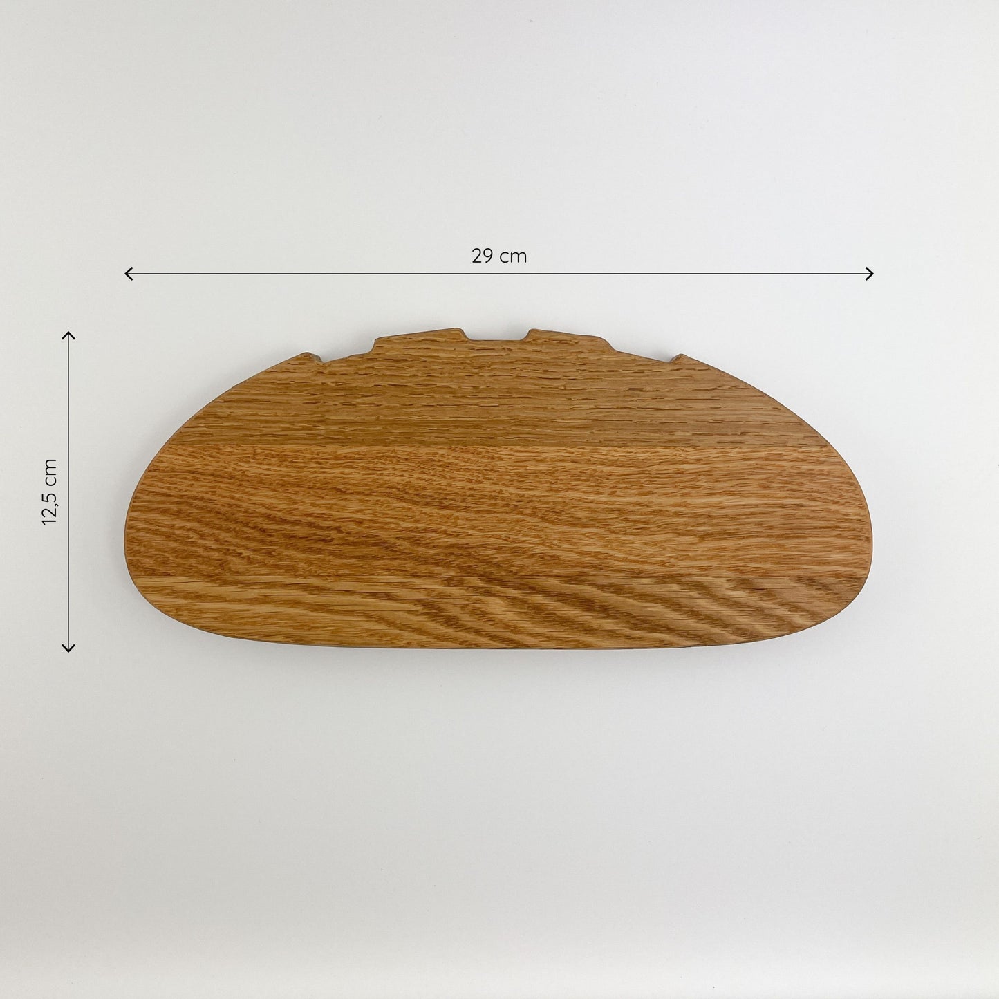 Frontansicht von Holz Schneidebrett - Bernd mit den Maßen 29 cm Breite und 12,5 cm Höhe, auf einem einfarbigen hellen Hintergrund. Die Maserung des Holzes ist deutlich sichtbar und zeigt eine natürliche, warme Farbgebung.