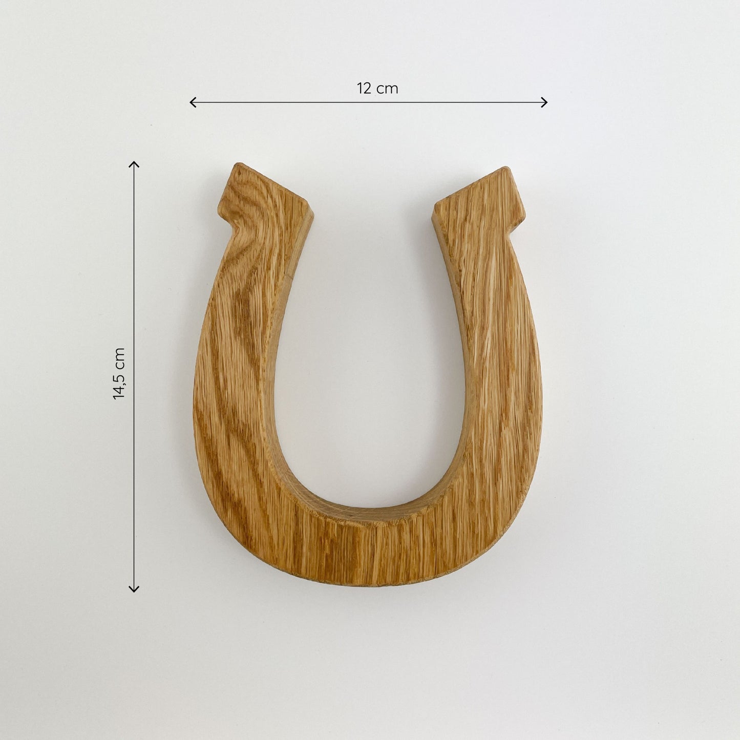 Frontalansicht von Hufeisen aus Holz - Hugo, präsentiert auf einem weißen Hintergrund mit natürlicher Holzmaserung, vertikal ausgerichtet vor einem weißen Hintergrund. Der Magnet misst 12 cm in der Breite und 14,5 cm in der Höhe.