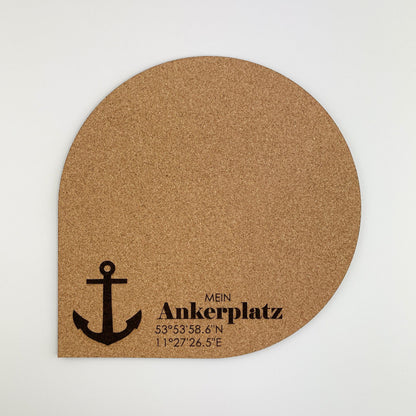 Frontansicht von ein halbrundes Mousepad aus Kork material mit einem aufgedruckten schwarzen Anker in der unteren Mitte. Über dem Anker steht der Text “MEIN ANKERPLATZ” in schwarzer Schrift, darunter sind Koordinaten “53°53’58.6"N 1°02’26.5"E” angegeben.