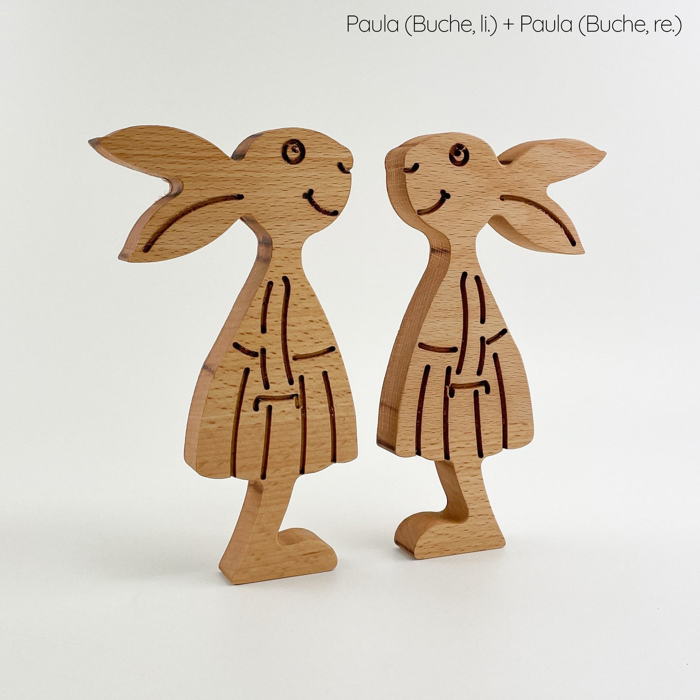 Hier sind Paula und Paula, zwei stilvolle Osterhasen aus Holz. Beide sind aus Buchenholz gefertigt und haben detaillierte Gravuren, die ihre Merkmale und Kleidung hervorheben. Perfekt für die Osterdekoration!