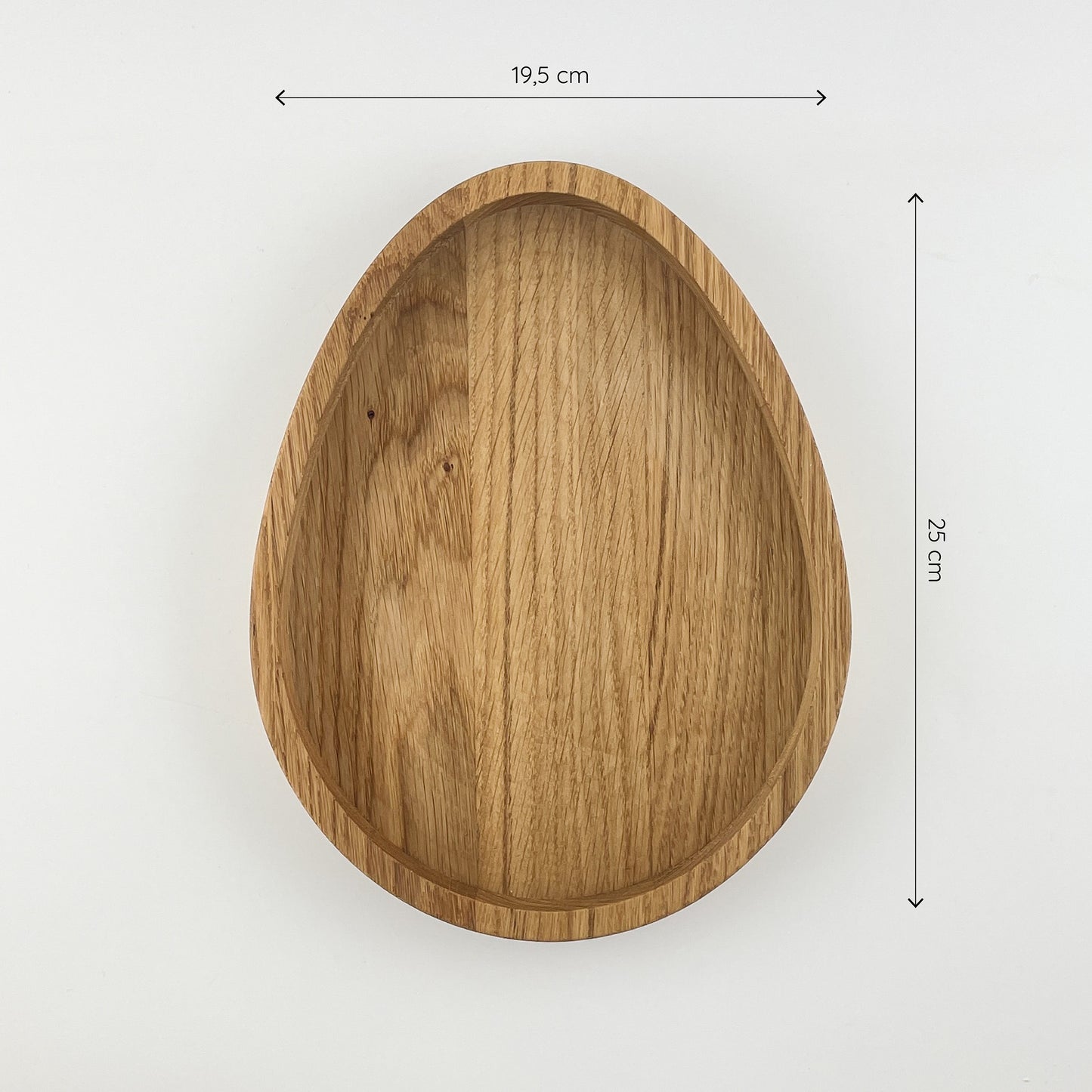 Die ei-förmige Schale aus massivem Eichenholz von oben gesehen vor weißem Hintergrund. Oberhalb und rechts von der Osterschale sind zwei Maßketten zu sehen, welche die Größe angeben - die Dekoschale ist 19,5cm breit und 25cm hoch.