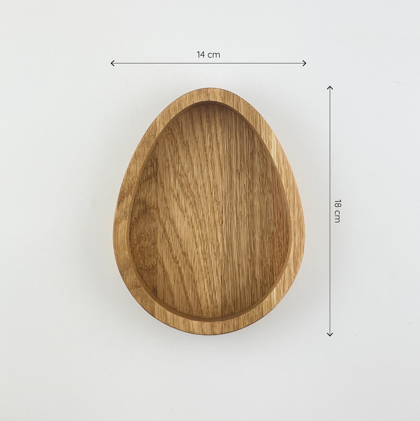 Eine Holzschale in Ei-Form als Osterdeko von oben gesehen vor einem weißen Hintergrund. Oben und rechts neben der Osterschale sind Maßketten zu sehen, welche die Größe definieren - sie ist 14cm breit und 18cm hoch.