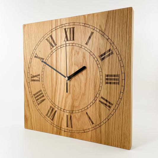 Perspektivansicht der quadratischen Eichenholz-Wanduhr Remus mit römischen Ziffern I bis XII und schwarzen schleichenden Zeigern vor heller Holzmaserung.