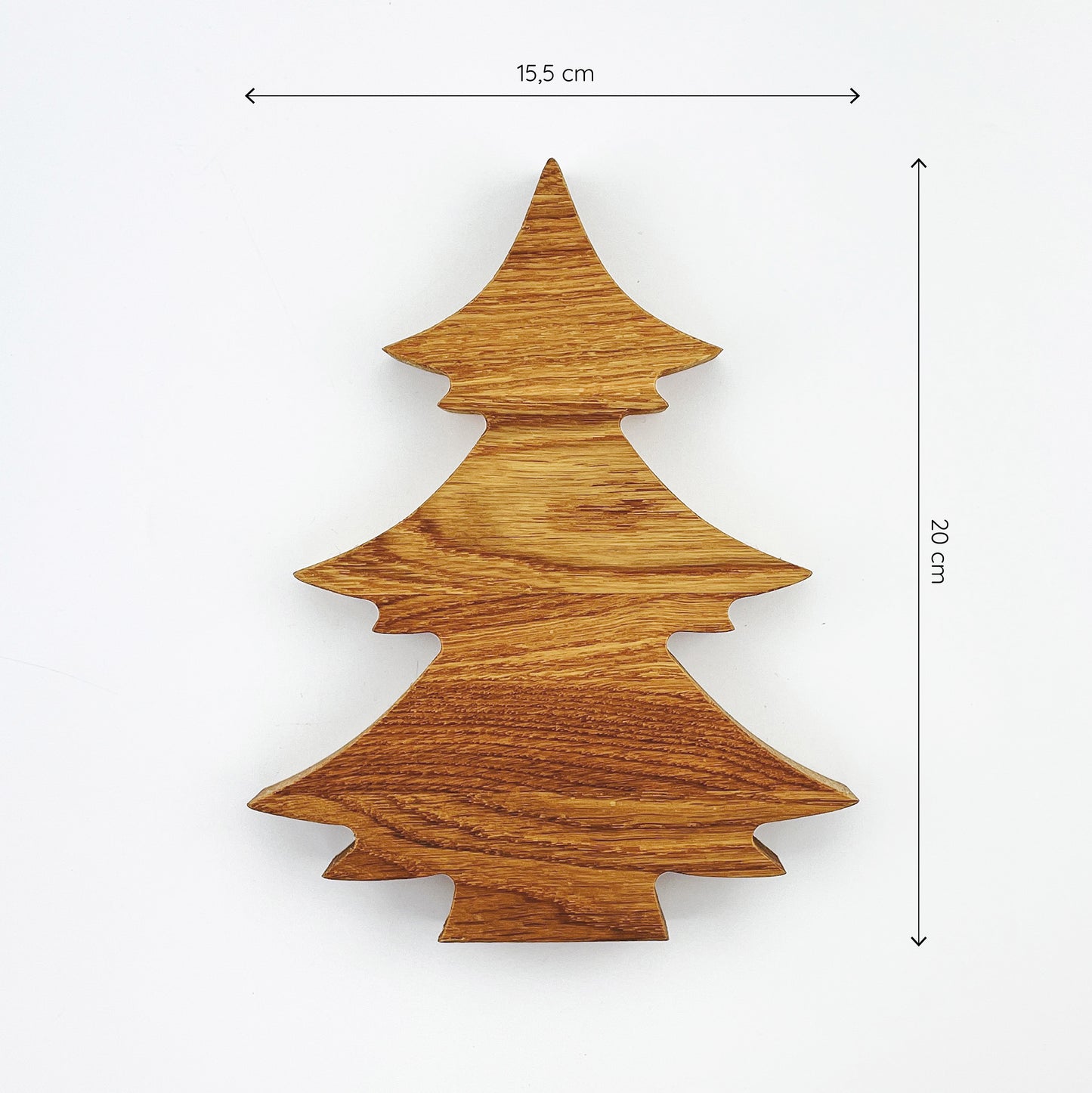 Deko-Tannenbaum aus (Eichen-) Holz vor weißem Hintergrund. Die Maserung des Holzes verläuft quer. Über sowie neben dem Tannenbaum sind Maßketten zu sehen, welche die Größe anzeigen - er ist 15.5cm breit und 20cm hoch.